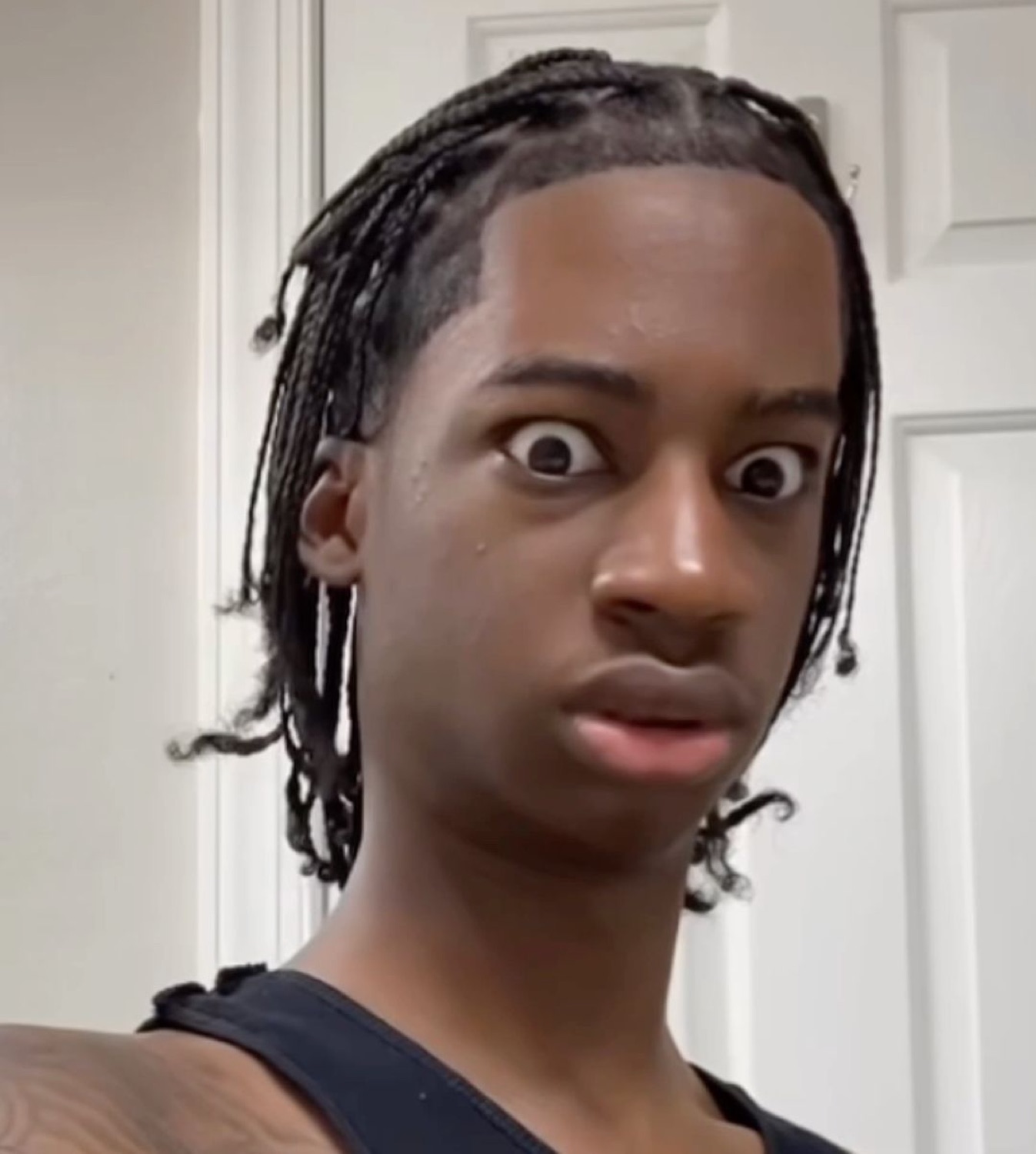 Young guy with braids and bulging wide eyes in total disbelief