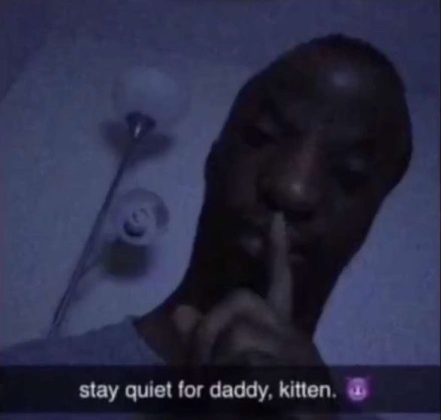 Dim photo of a man holding a finger to his lips with caption 'stay quiet for daddy, kitten.'