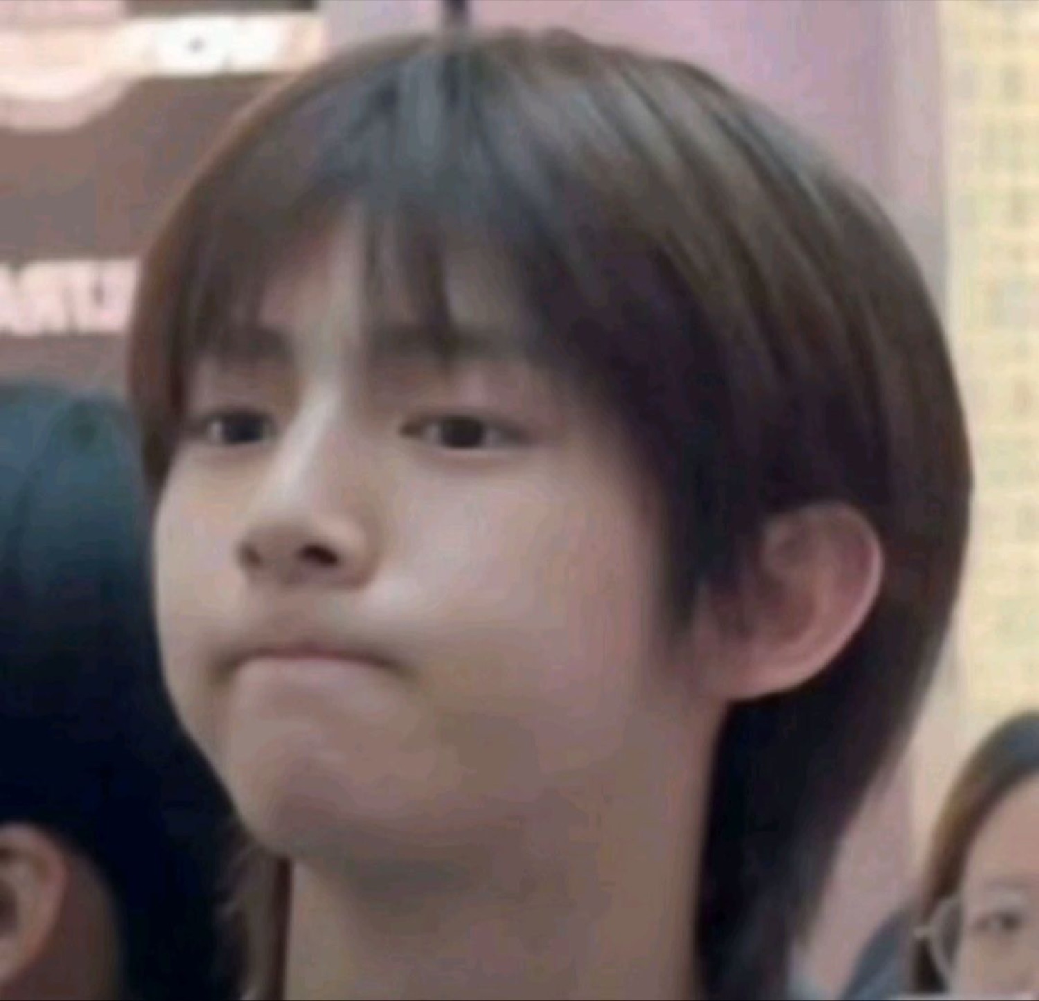 Young person pressing their lips together with an unamused, over-it expression