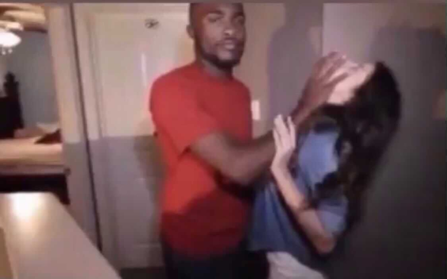 Guy in a red shirt hauling a laughing woman across the room mid-scuffle