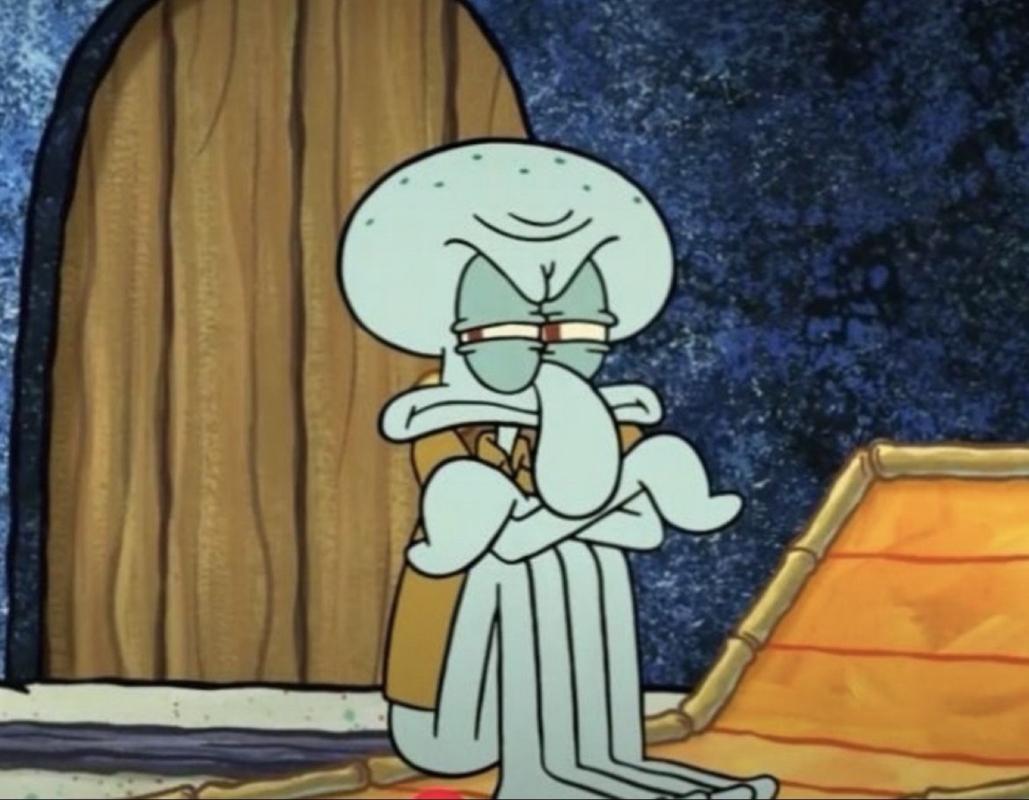 Squidward sitting hunched over with arms crossed, looking deeply done with everything