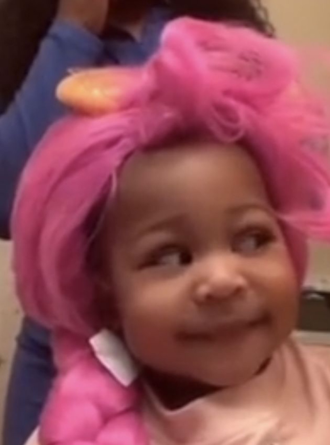 Toddler in a giant pink hair bow serving a smug little side-eye smile