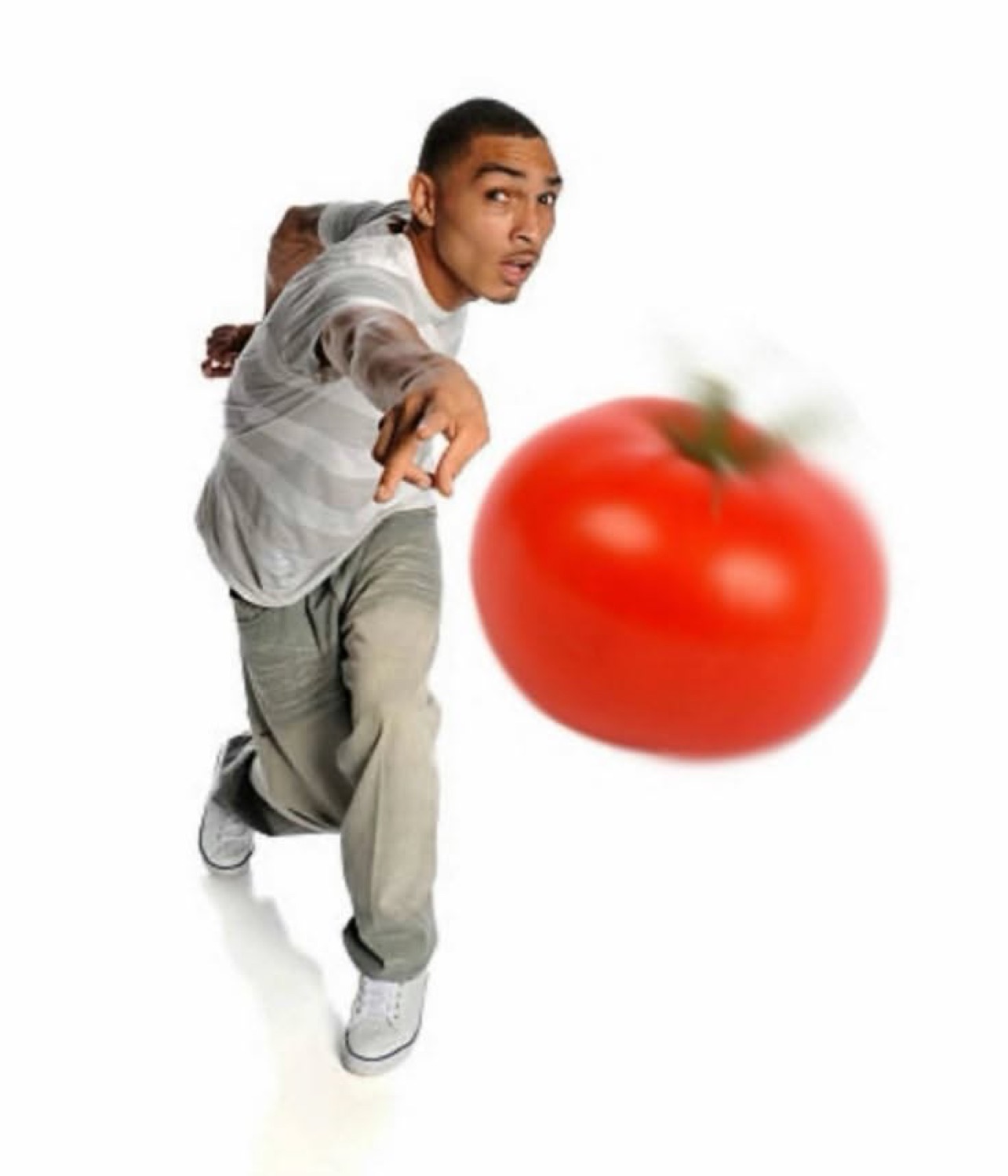 Guy mid-throw launching a giant tomato straight at the camera