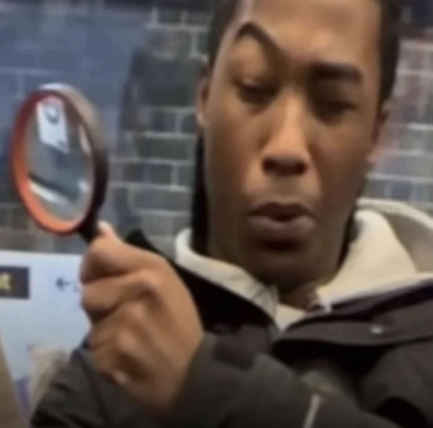 Guy peering through a magnifying glass with a deeply concentrated, skeptical look