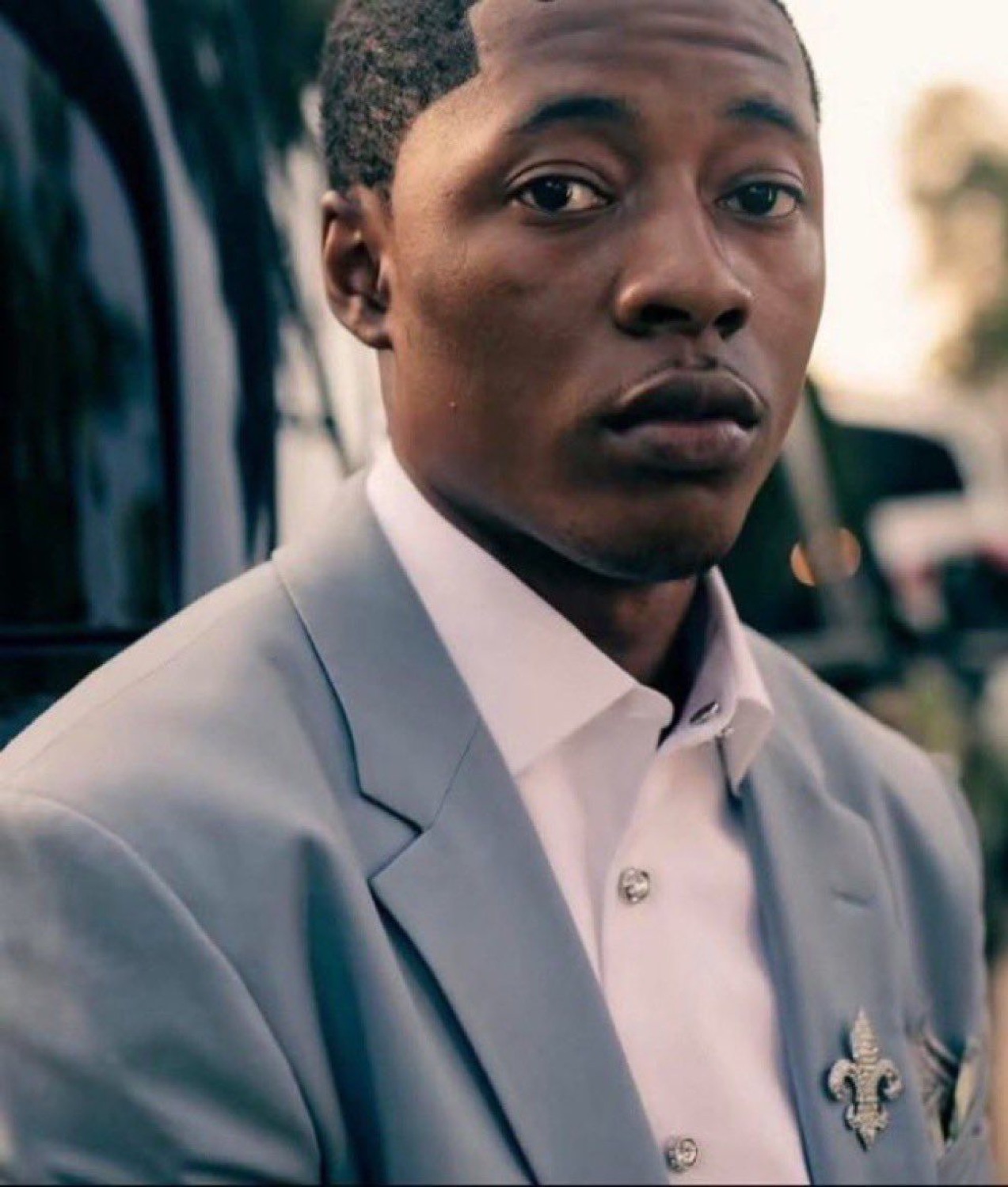 Young man in a gray suit giving a deeply skeptical side-eye over his shoulder