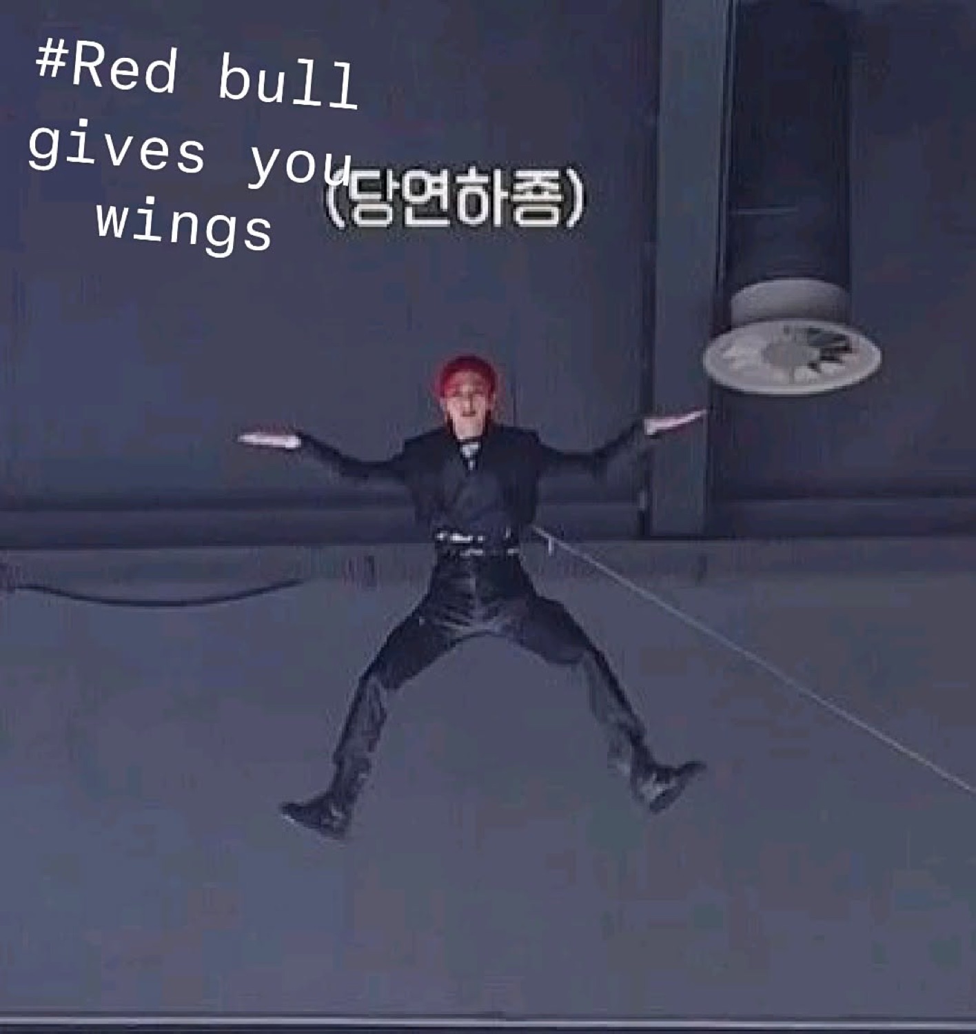 Person in all black suspended mid-air on stage captioned '#Red bull gives you wings'