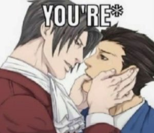 Anime guy grabbing another's face up close, captioned only 'YOU'RE*'