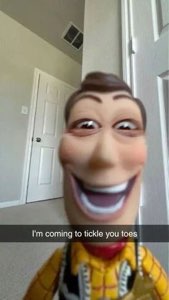 Woody doll from Toy Story looming into the camera with a wild grin, 'I'm coming to tickle you toes'