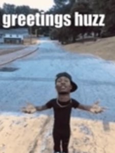 Man with arms spread wide and a big grin captioned 'greetings huzz'