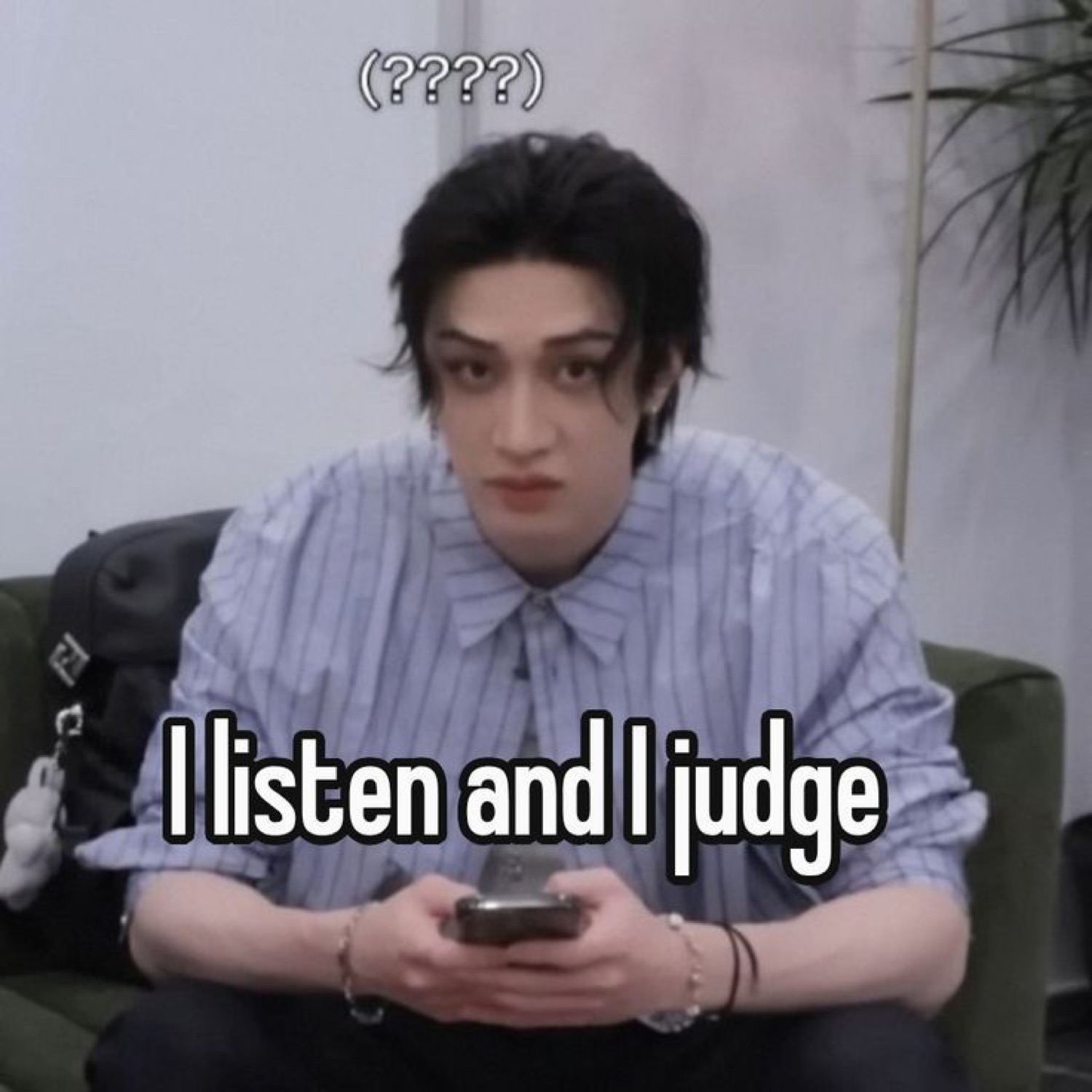 Deadpan person on a couch holding a phone, captioned 'I listen and I judge'