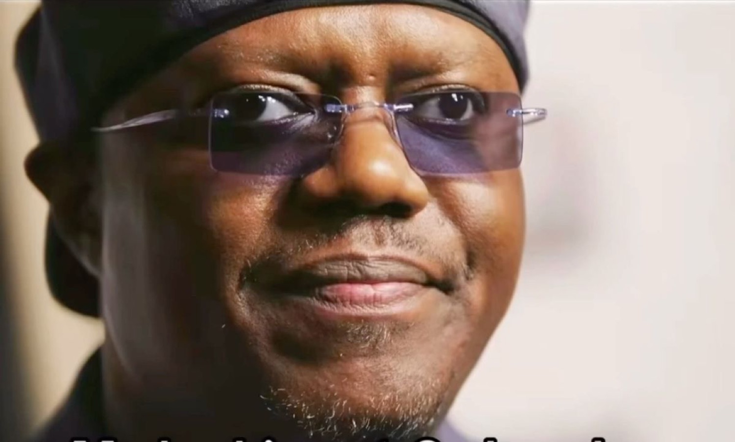 Bernie Mac in tinted glasses smirking