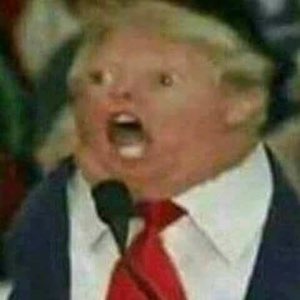 Blurry close-up of a man in a suit yelling open-mouthed at a microphone