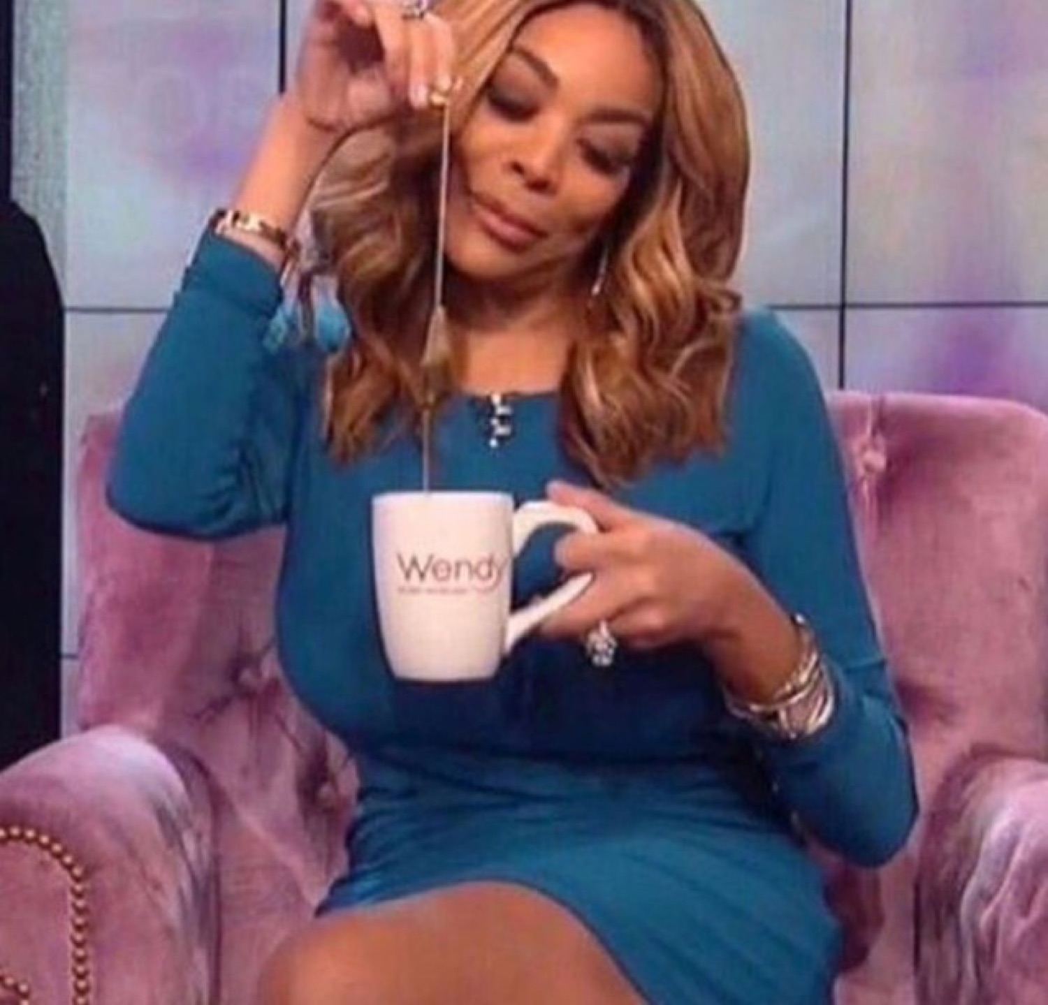 Woman sipping from a Wendy mug with a knowing, judgmental look