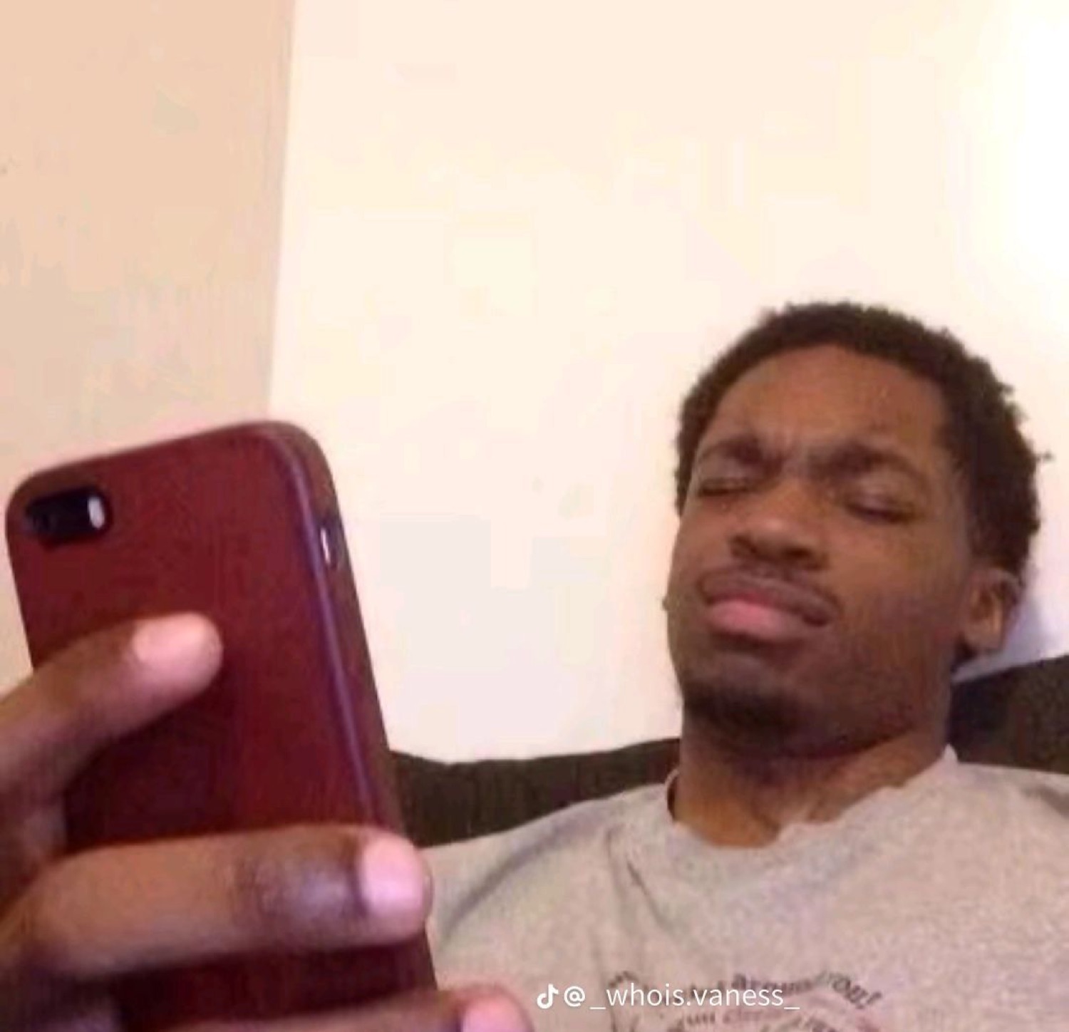 Man squinting at his phone with a disgusted look