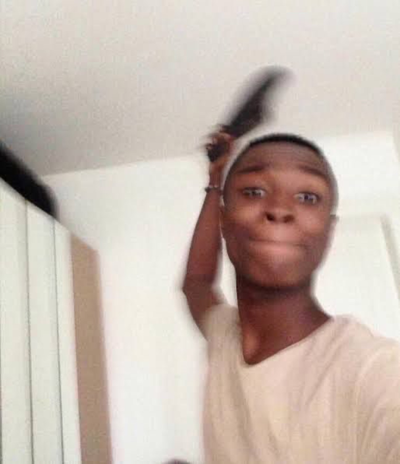 Guy holding a shoe over his head with a completely calm, unbothered expression