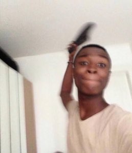 Guy holding a shoe over his head with a completely calm, unbothered expression