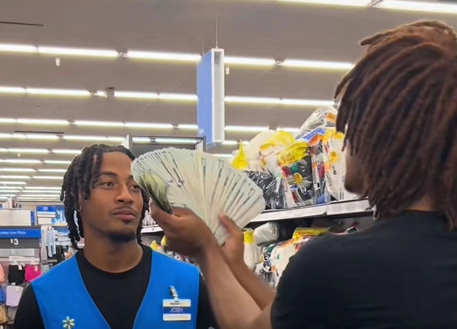 Walmart employee in a blue vest looking completely unbothered while someone fans cash in his face