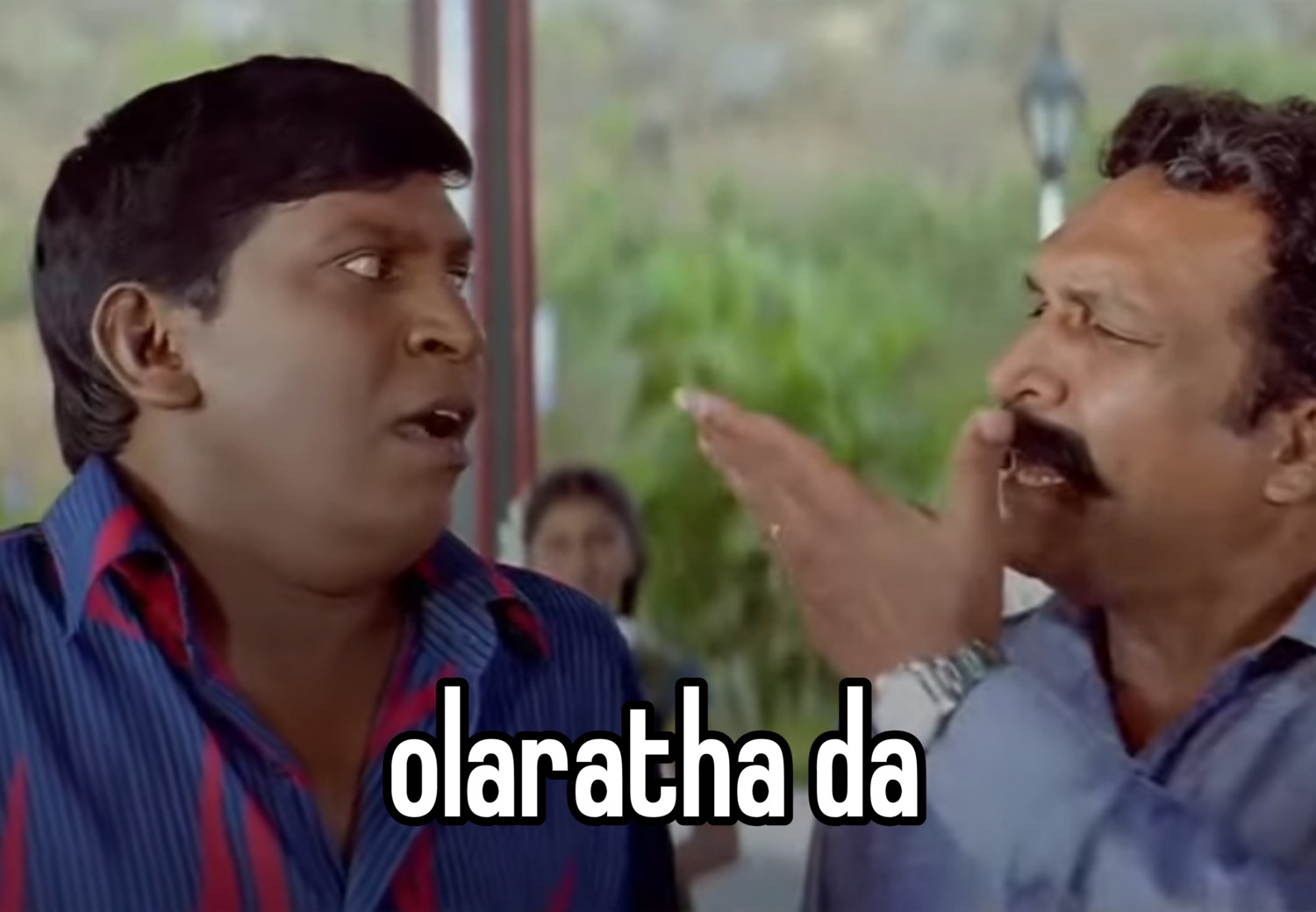 Vadivelu staring as a man shushes him: 'olaratha da' (stop babbling)