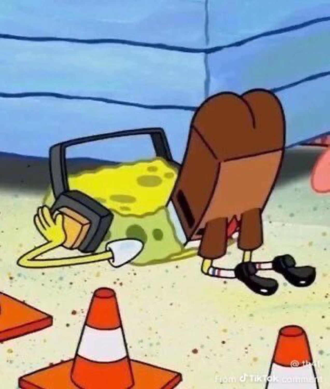 SpongeBob face-down on the ground holding a jackhammer