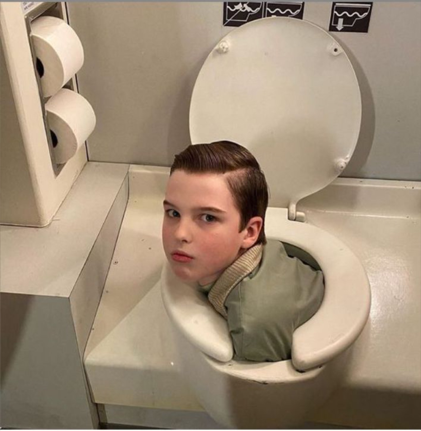 Young Sheldon's head and shoulders poking out of a toilet
