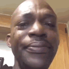 Bald man staring ahead as a single tear rolls down his cheek