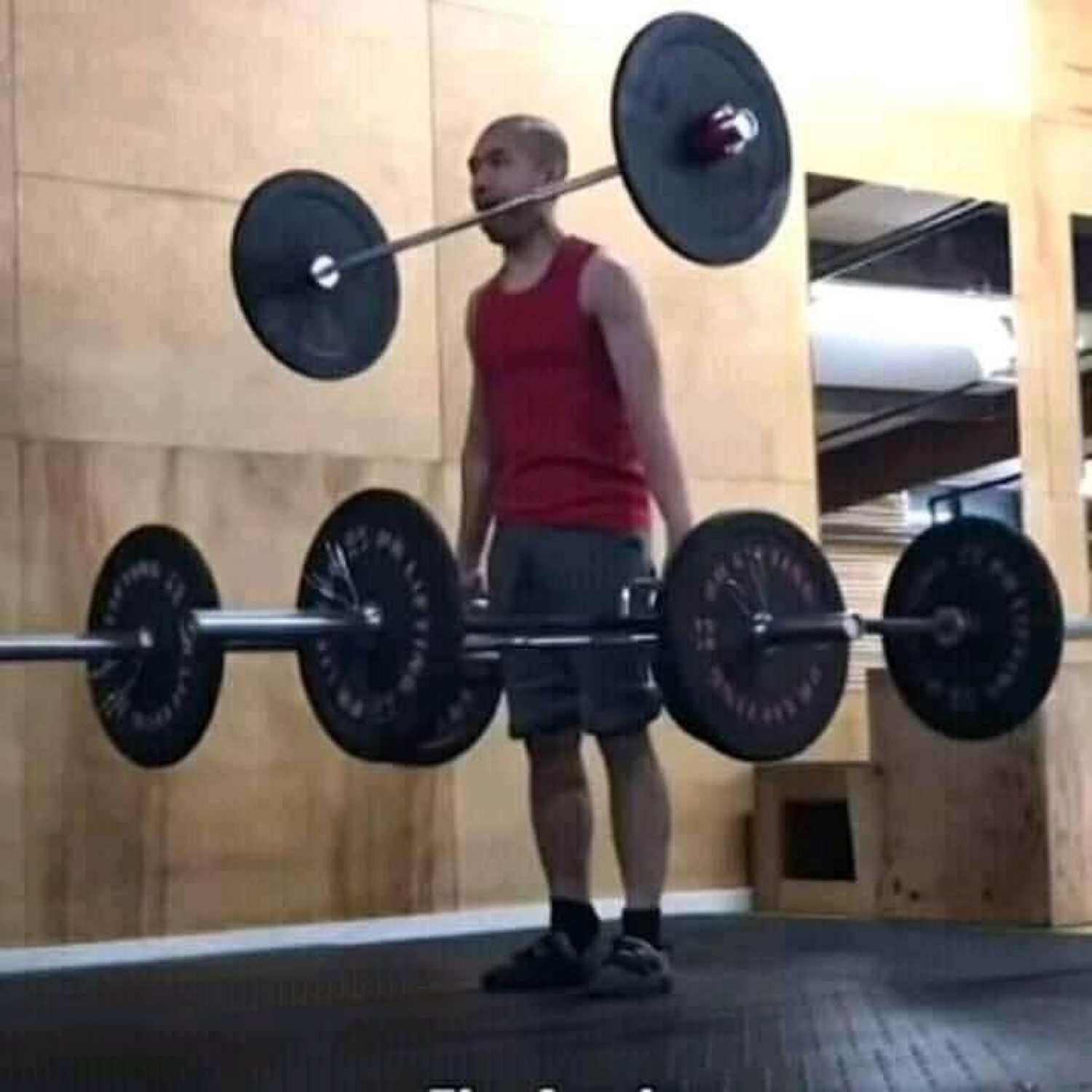 Guy staring at a barbell loaded with way too many plates