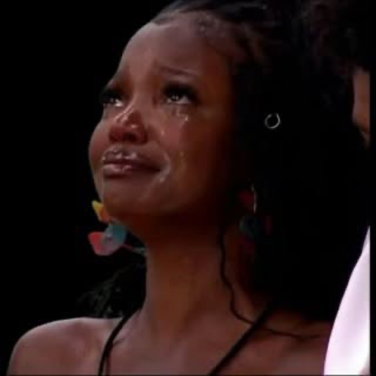 Young woman on a dark stage with tears streaming down her face