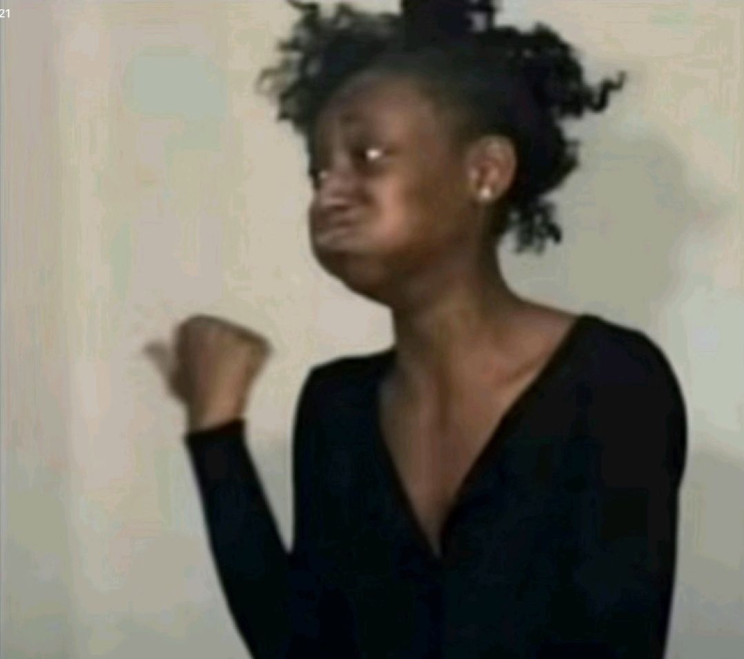 Woman puffing out her cheeks with eyes squeezed shut and a fist raised, holding it in