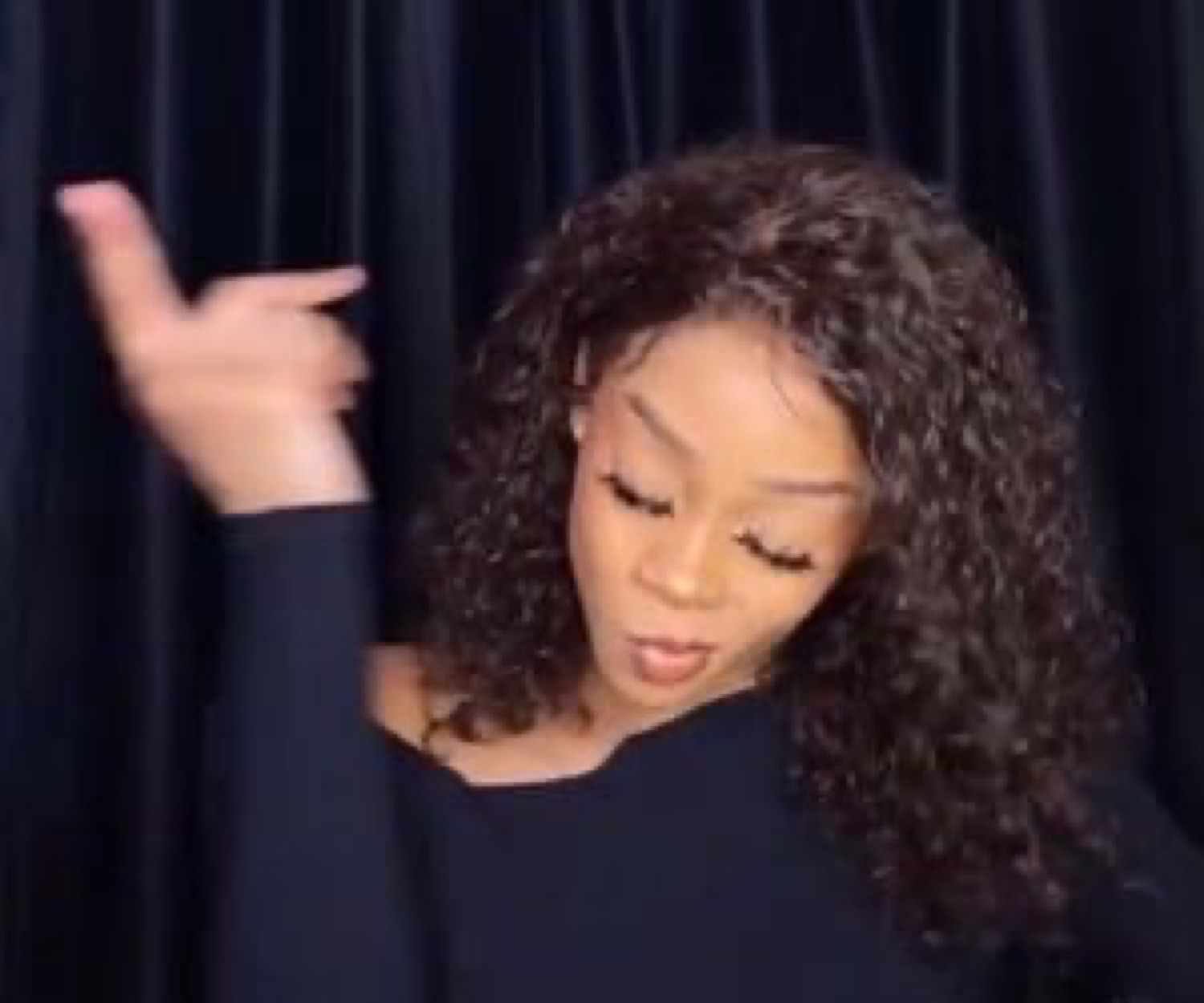 Woman throwing a 'sheesh' hand flick with eyes closed