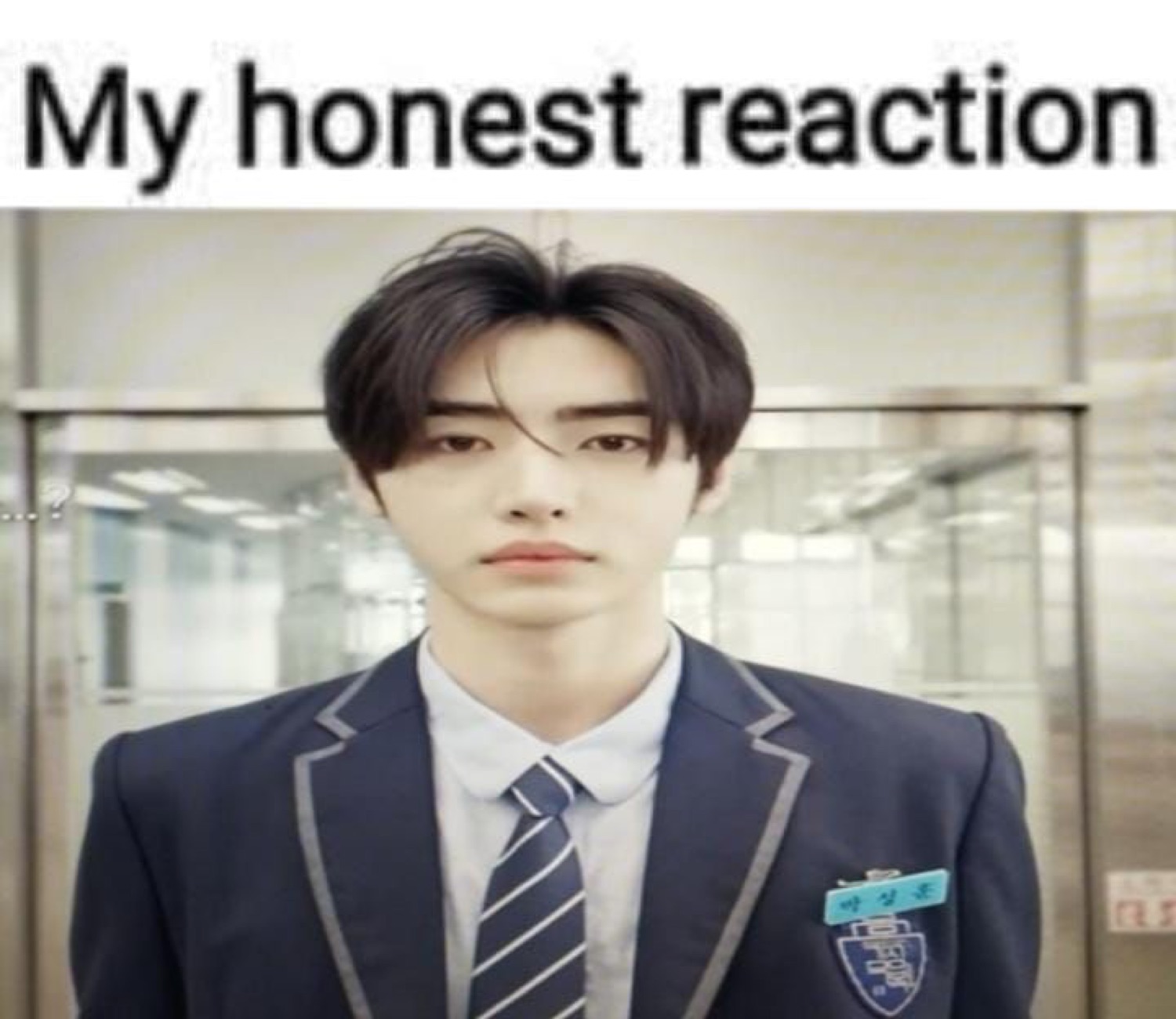 Young man in school uniform staring forward with zero expression, captioned 'My honest reaction'