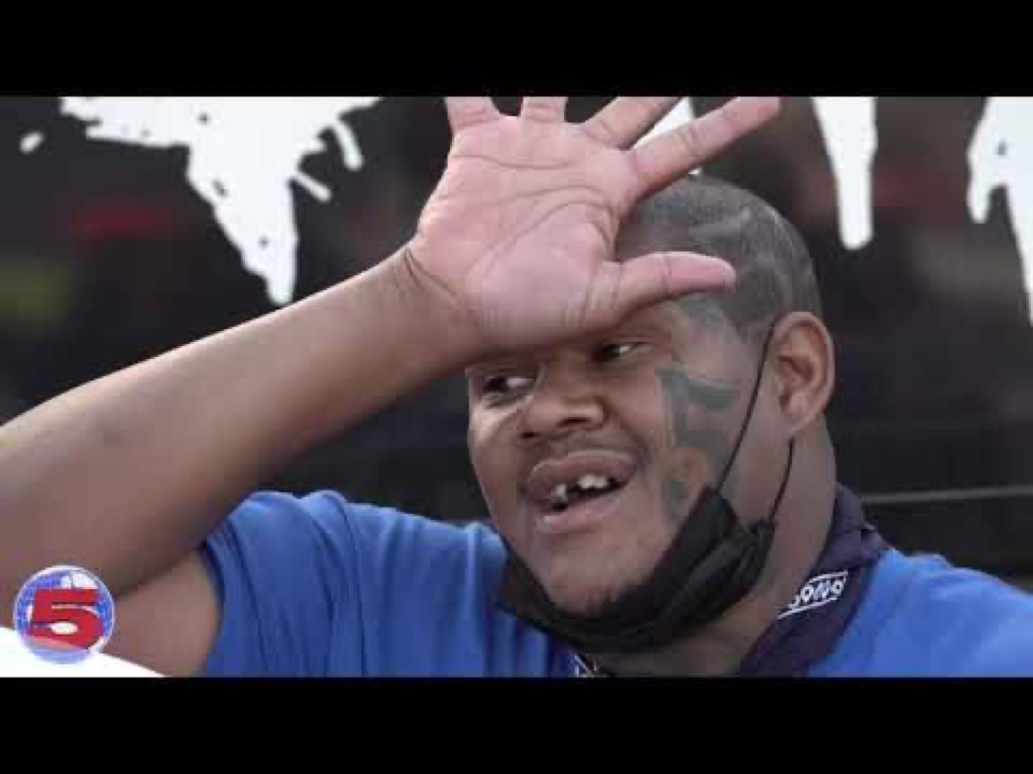 Crip Mac laughing with a hand on his forehead