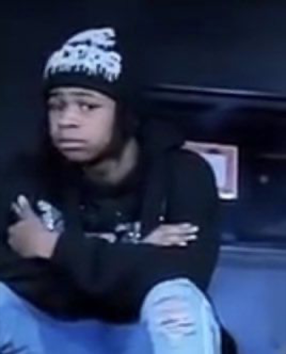 Teen in a beanie with arms crossed throwing a suspicious side-eye
