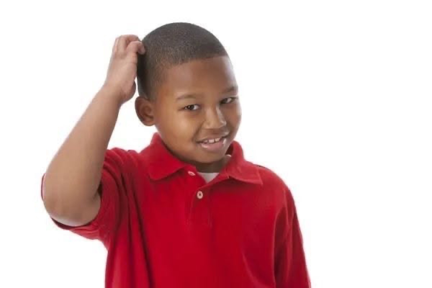 Young boy in a red polo scratching his head and grinning, completely stumped
