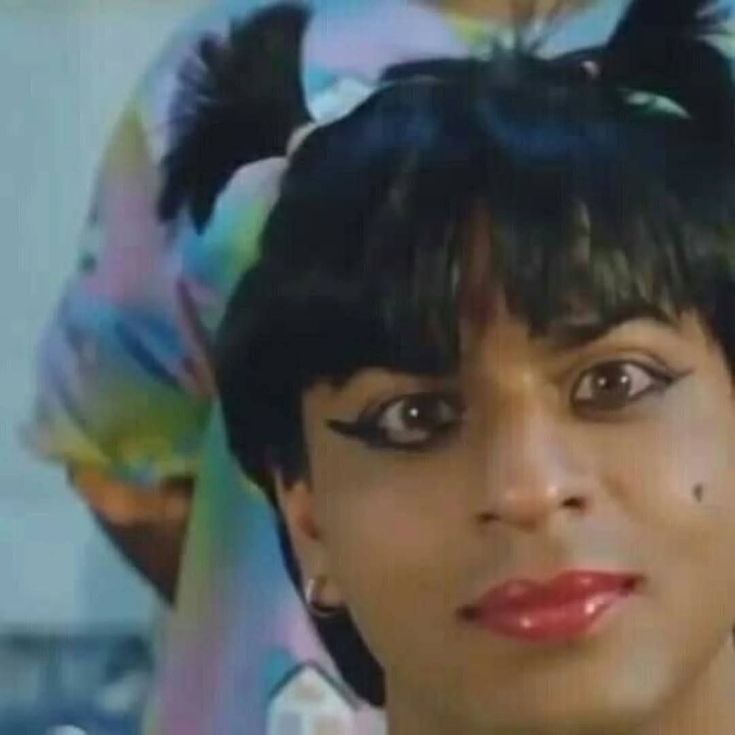 Shah Rukh Khan in pigtails and eyeliner giving a coy look