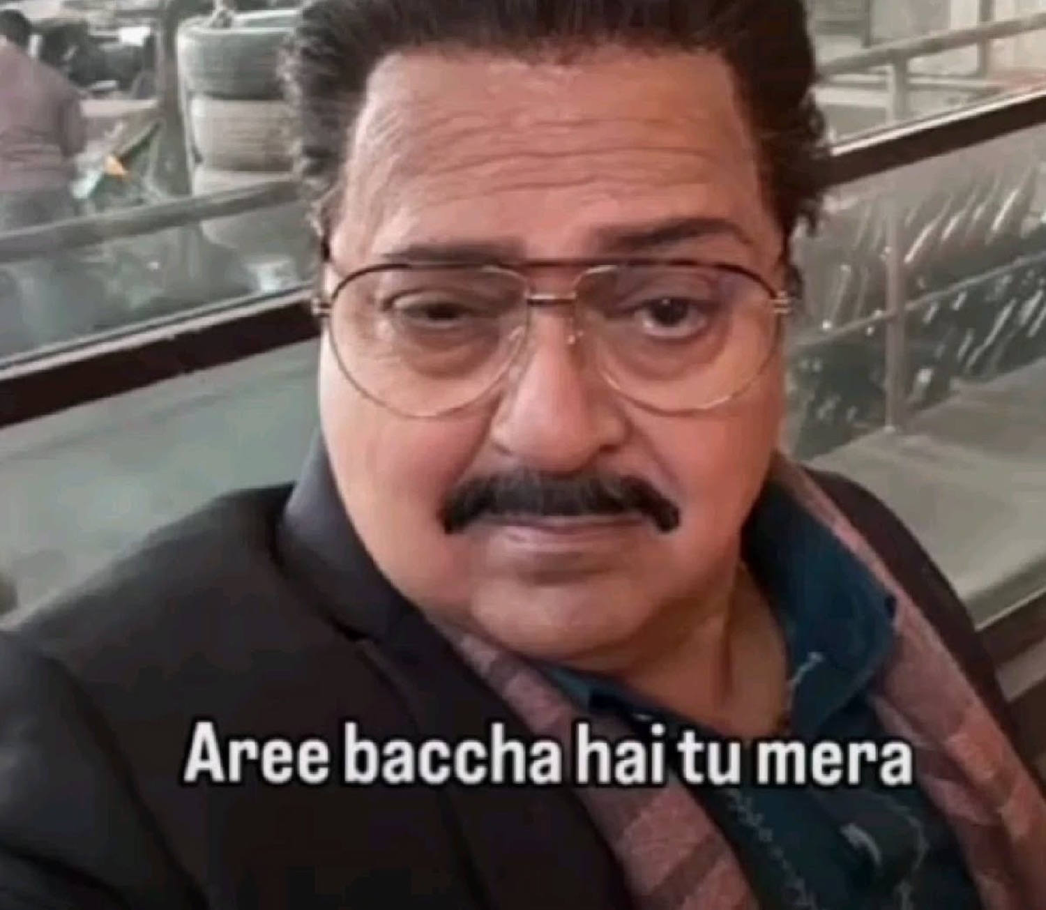 Older man in glasses giving a knowing look: 'Aree baccha hai tu mera' (you're just a kid to me)