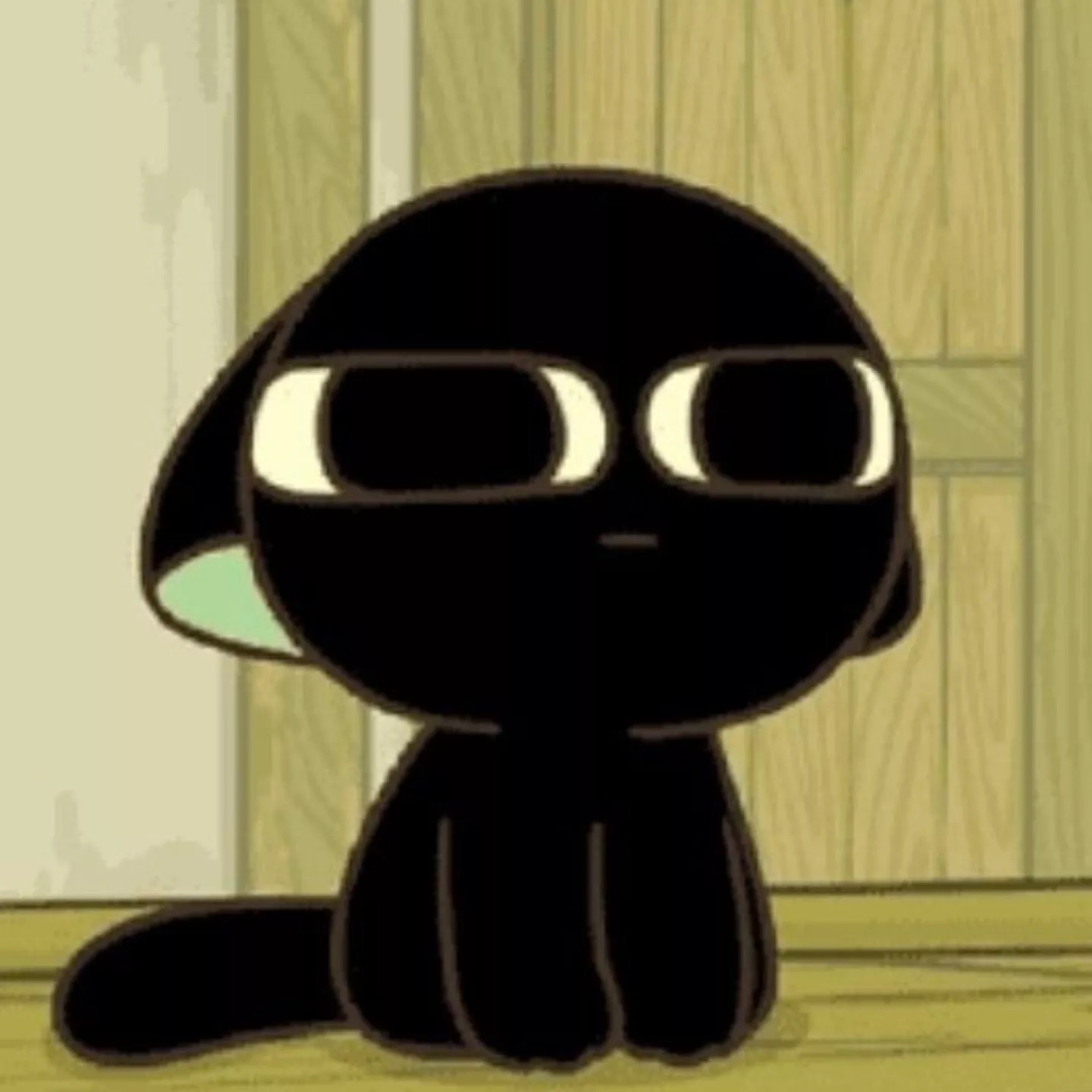 Little black cartoon cat sitting up front with a wide-eyed blank stare