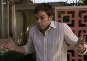 Man in a striped shirt shrugging with both palms out in a total 'what do you want from me' pose