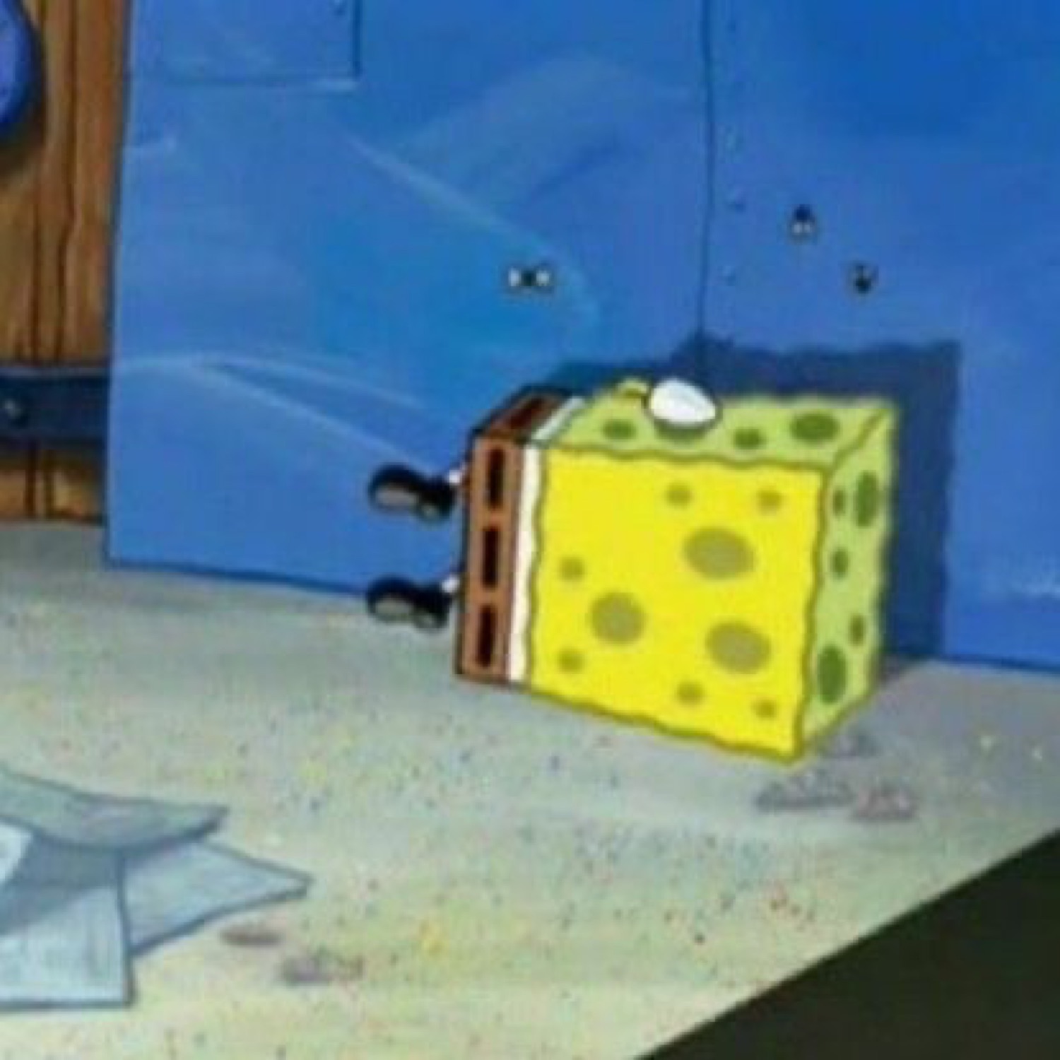 SpongeBob crouching flat and boxlike against a wall, looking tiny and withdrawn