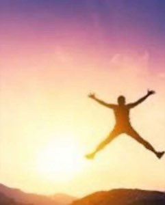 Silhouette leaping arms-wide against a purple and gold sunset