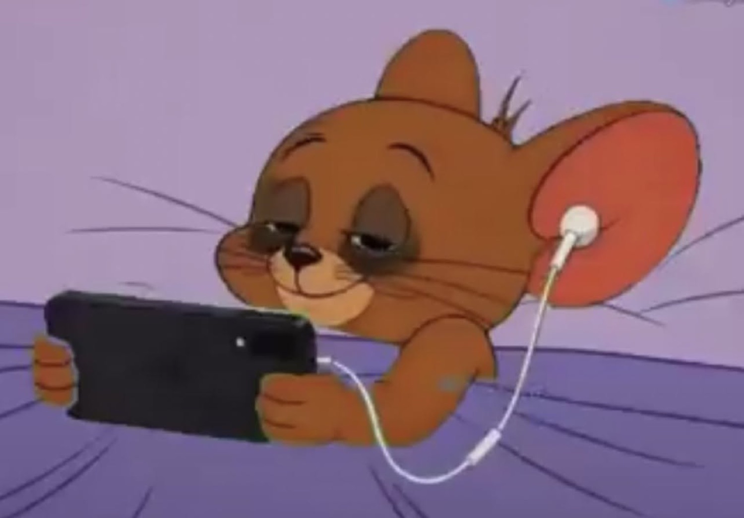 Jerry from Tom & Jerry lying in bed on his phone with earphones in, completely content