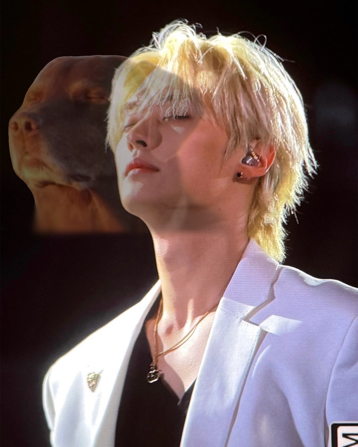 Blond-mullet performer in a white suit tilting his head back, a dog's face blended in behind