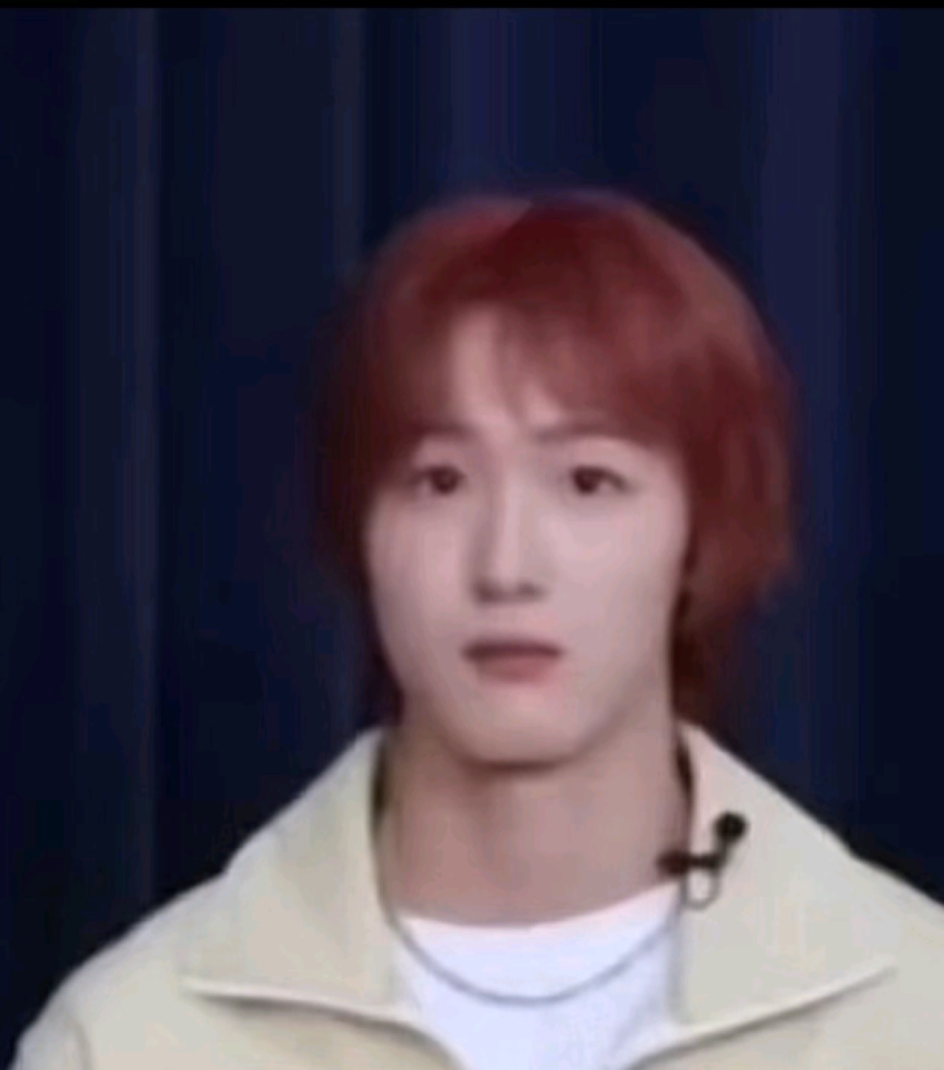 Red-haired young man staring blankly at the camera with a puzzled, slack expression