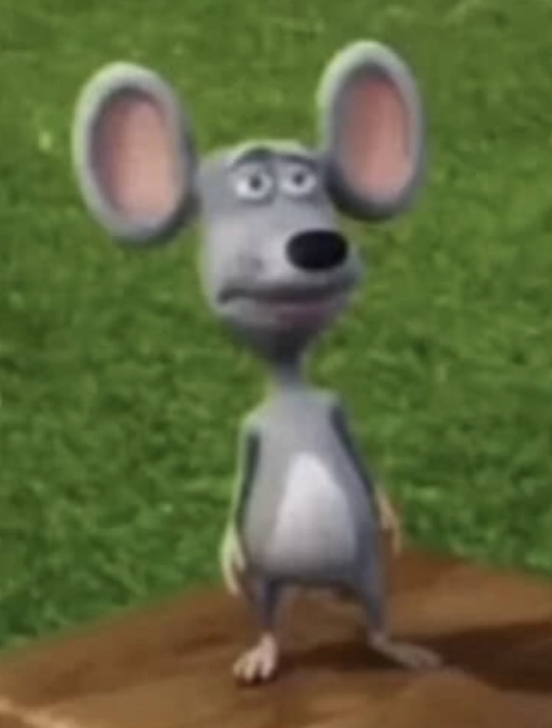 Big-eared animated mouse standing on a mound with a worried little frown