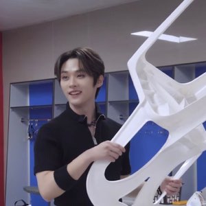 Smiling guy hoisting a big white chair up in a locker room
