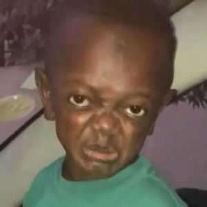 Young child with a deeply furrowed brow and a scowling glare directed straight at the camera