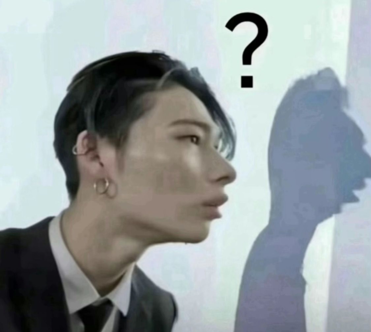 Young person in profile glancing sideways at their own shadow with a question mark overhead