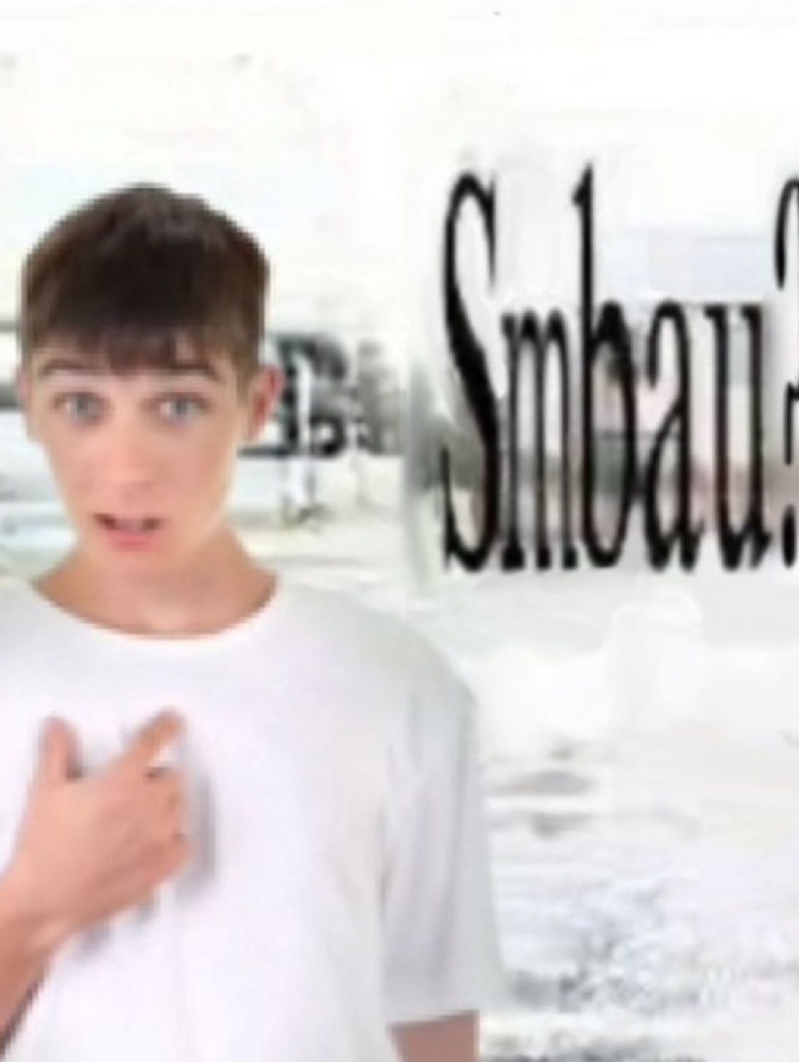 Teen pointing at his own chest mid-sentence with blurry 'Smbau' text behind him