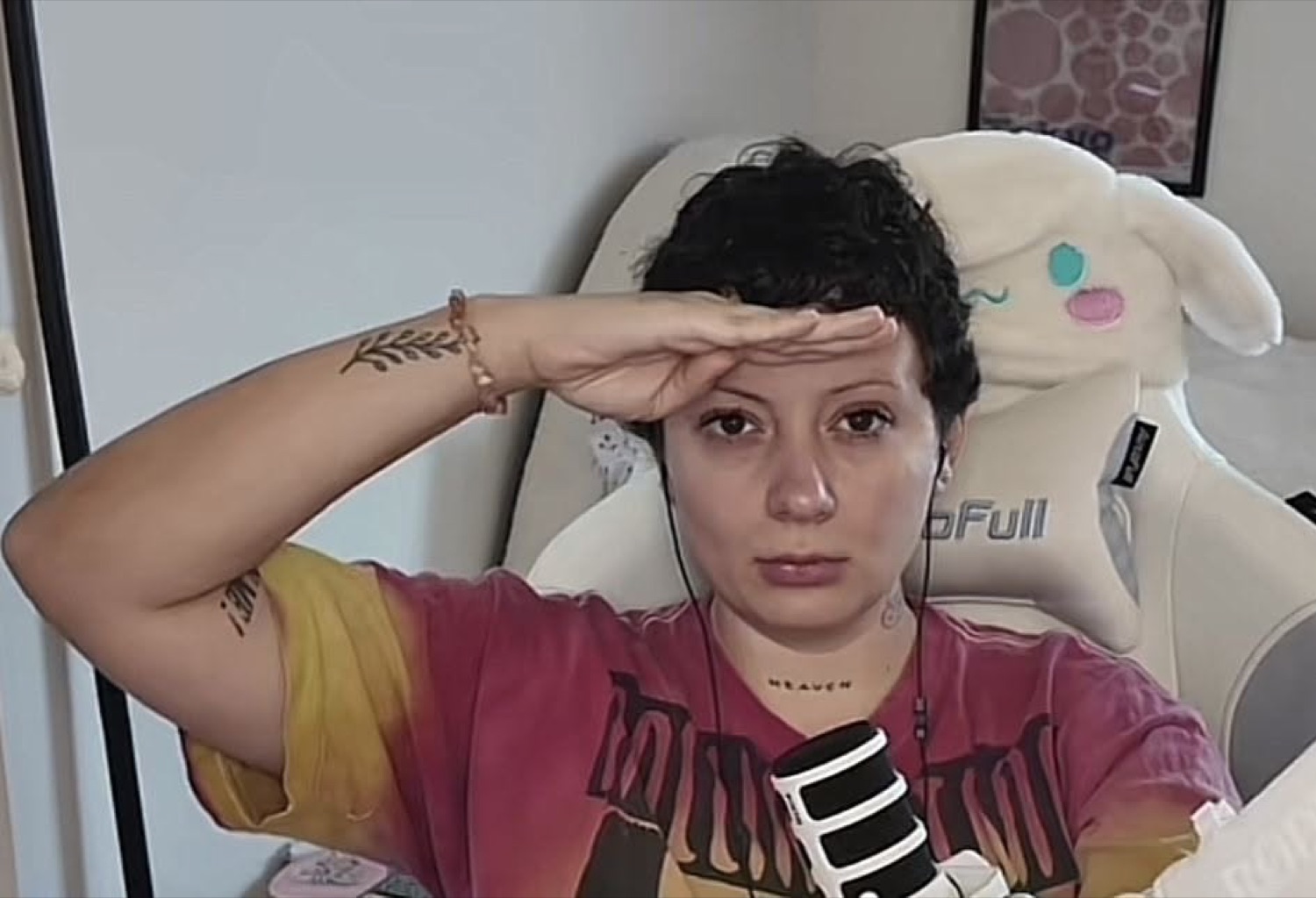 Streamer shading her eyes with one hand, scanning the distance with a flat face