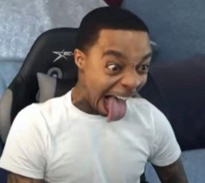 Man in a gaming chair pulling a wild goofy face with his tongue stretched out