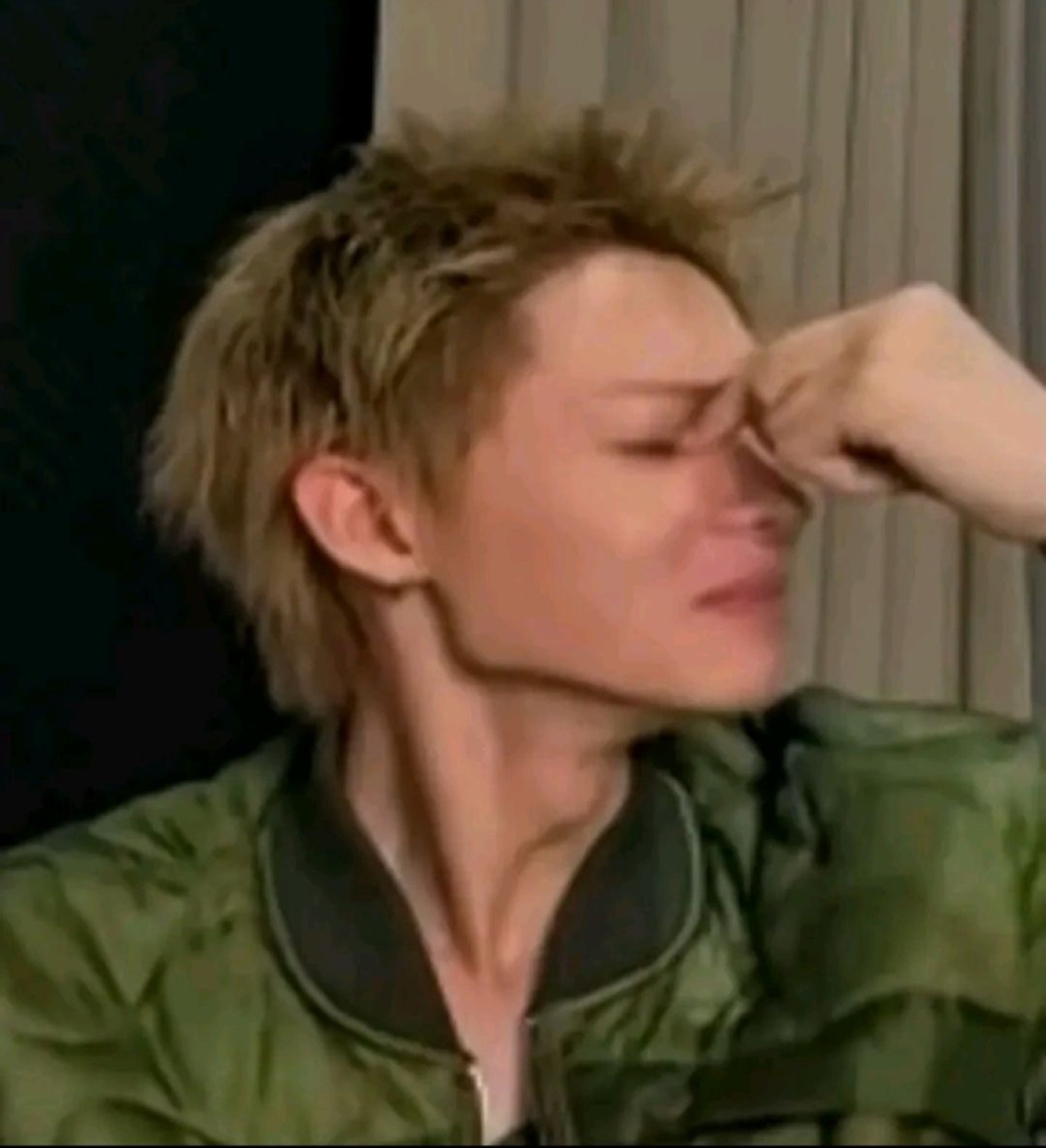Person with short blonde hair pinching the bridge of their nose with eyes shut in exasperation